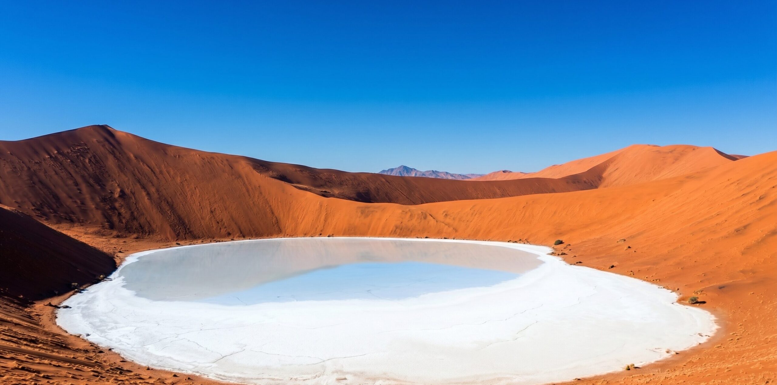 ナミブ砂漠のソッサスフレイ。白い塩と粘土の平地（パン）を高さ325mの赤い砂丘が取り囲む、ナミブ砂海を代表する絶景スポット。