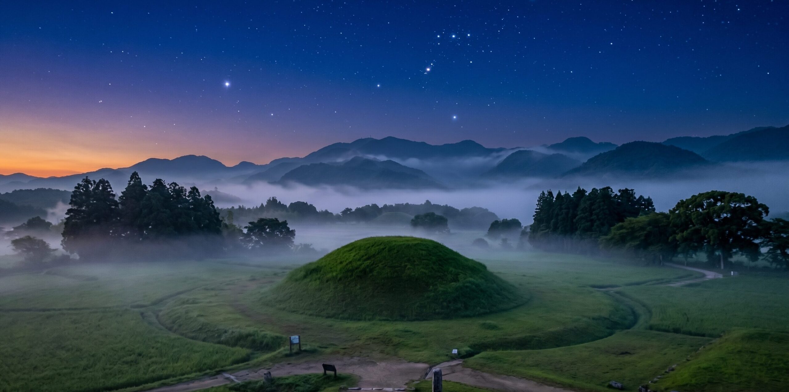 飛鳥の円墳と夕暮れの空。緑の墳丘と幻想的な霧と星空。奈良県明日香村 キトラ古墳 高松塚古墳 飛鳥・藤原の宮都