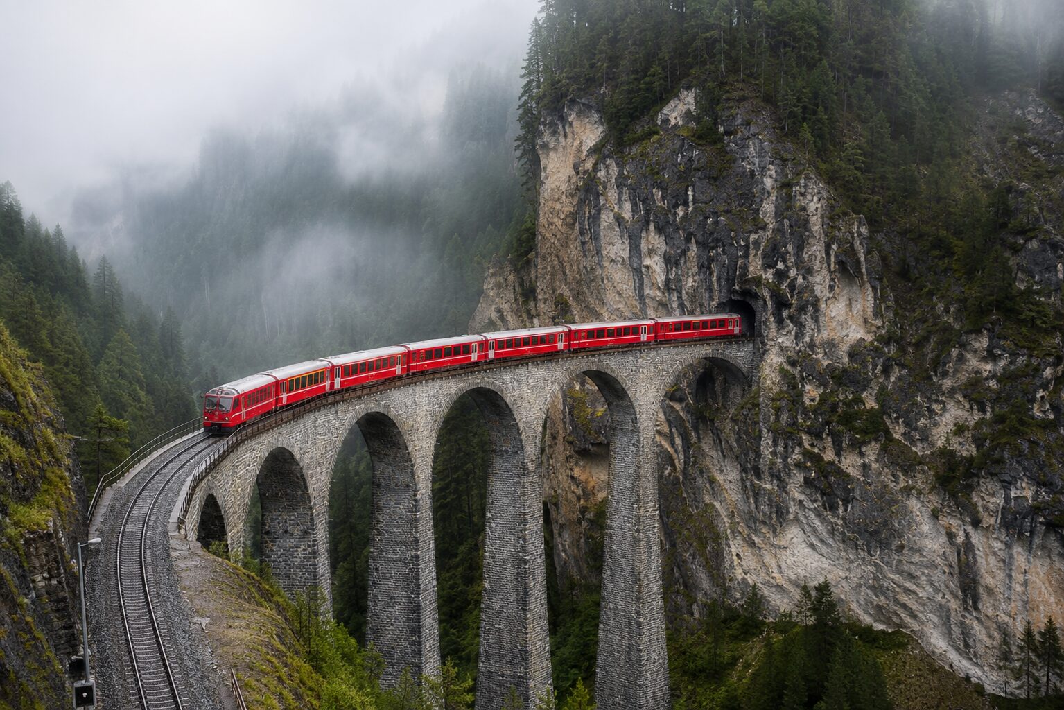断崖のトンネルへ吸い込まれる列車を望むランドヴァッサー橋の定番撮影地から見たレーティッシュ鉄道の絶景