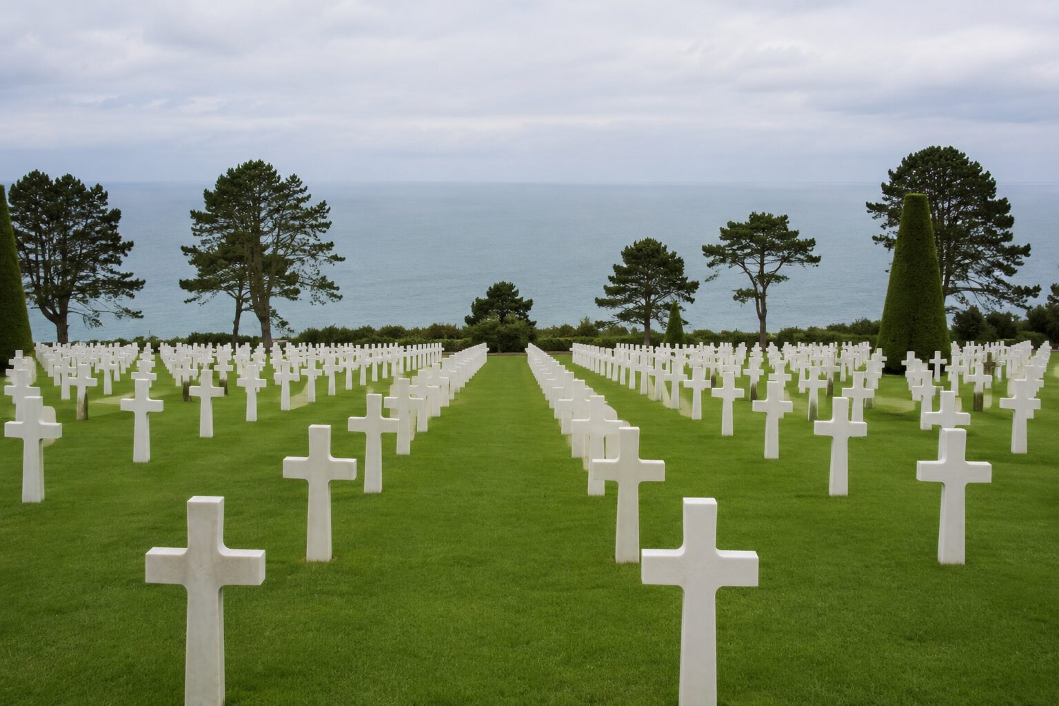 ノルマンディー・アメリカ人墓地に整然と並ぶ白い十字架と、世界遺産となったDデイ海岸を見下ろす追悼の風景