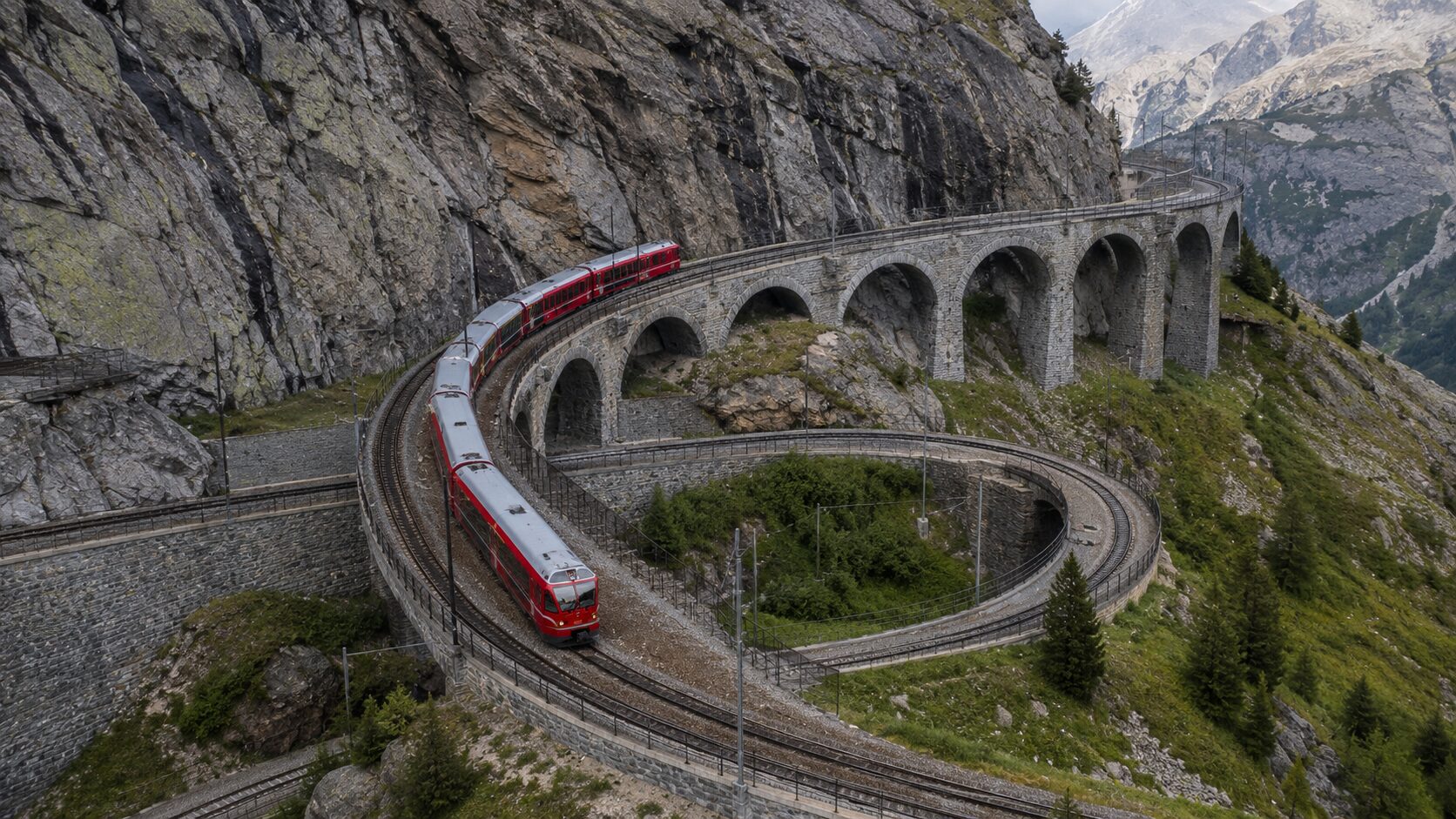 スイスアルプスの急勾配をループ橋で登るレーティッシュ鉄道の列車と山岳鉄道の土木技術がわかる俯瞰の風景
